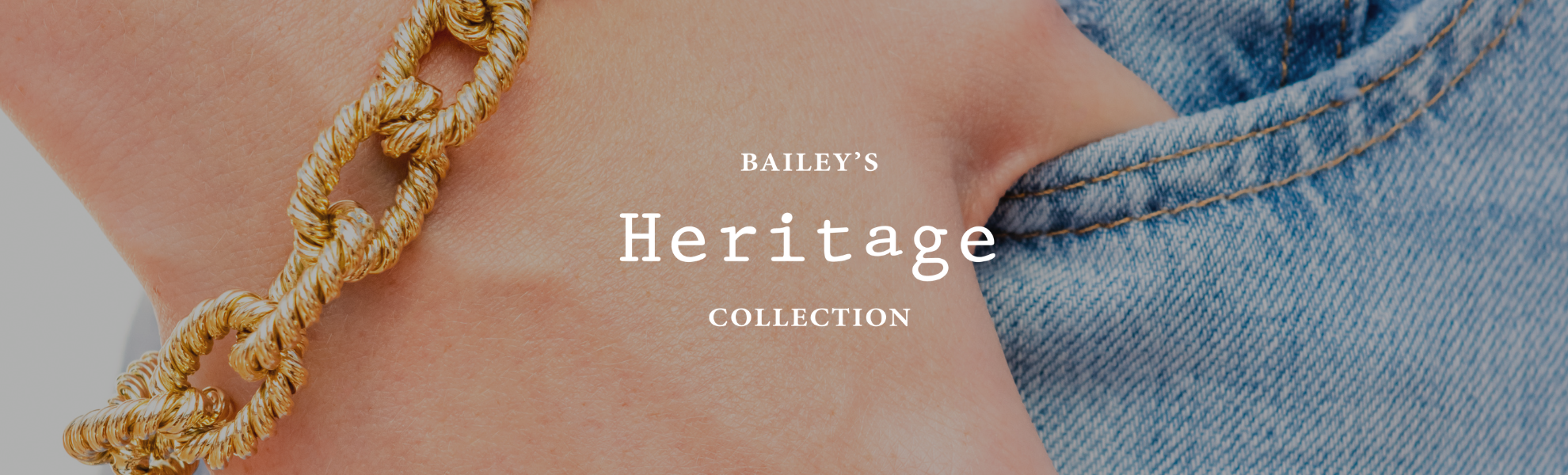 Gold chain bracelet on a wrist with 'Bailey's Heritage Collection' text.
