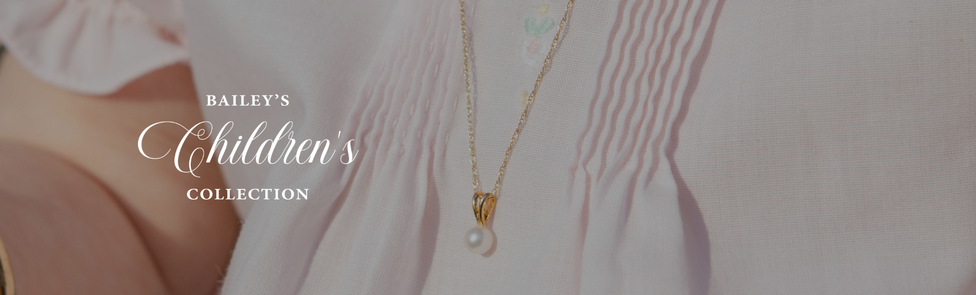 Gold necklace with a pearl pendant on a blurred background, featuring 'Bailey's Children's Collection' text.