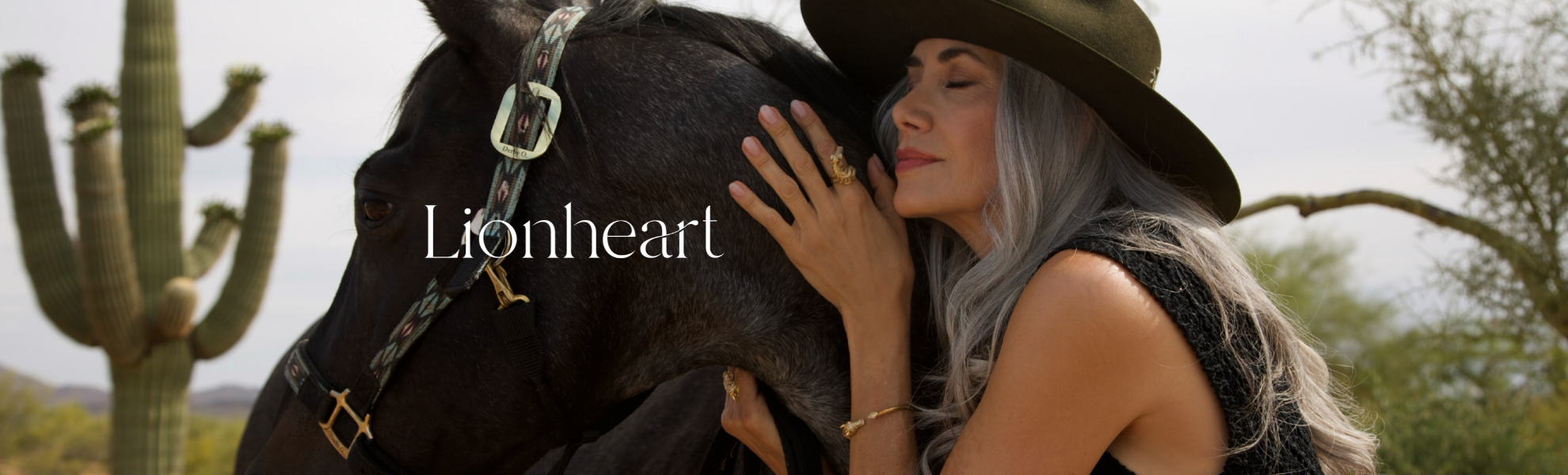 Woman embracing a horse with cacti and desert landscape in the background, featuring the brand 'Lionheart'.