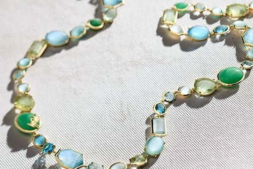 Necklace with green and blue gemstones on a light background