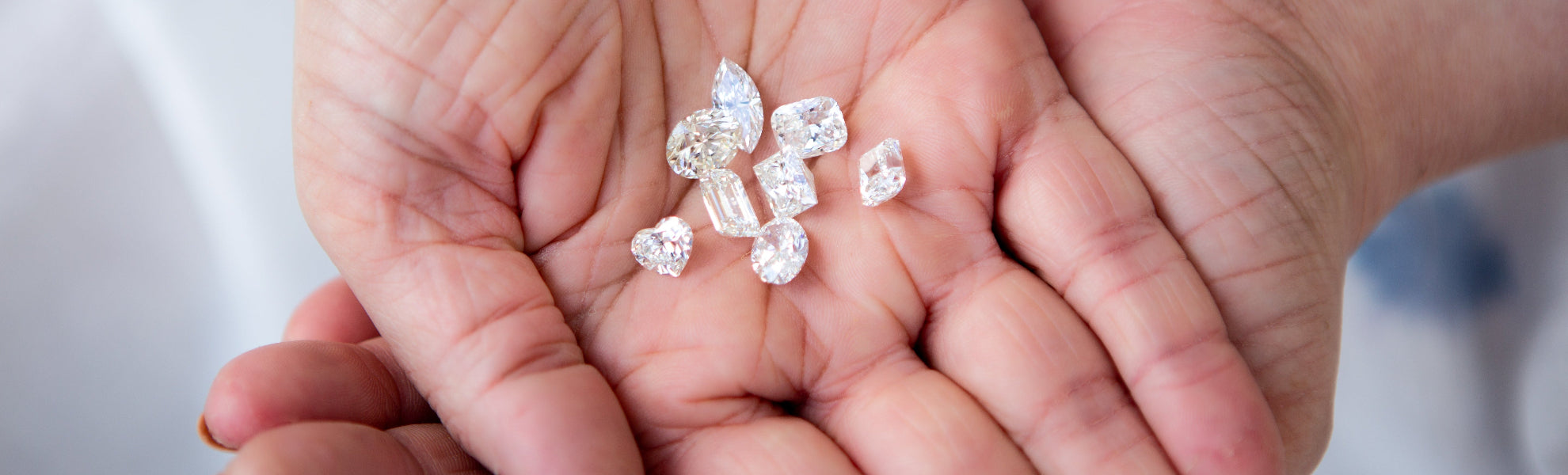 Hands holding small diamonds with a blurred background
