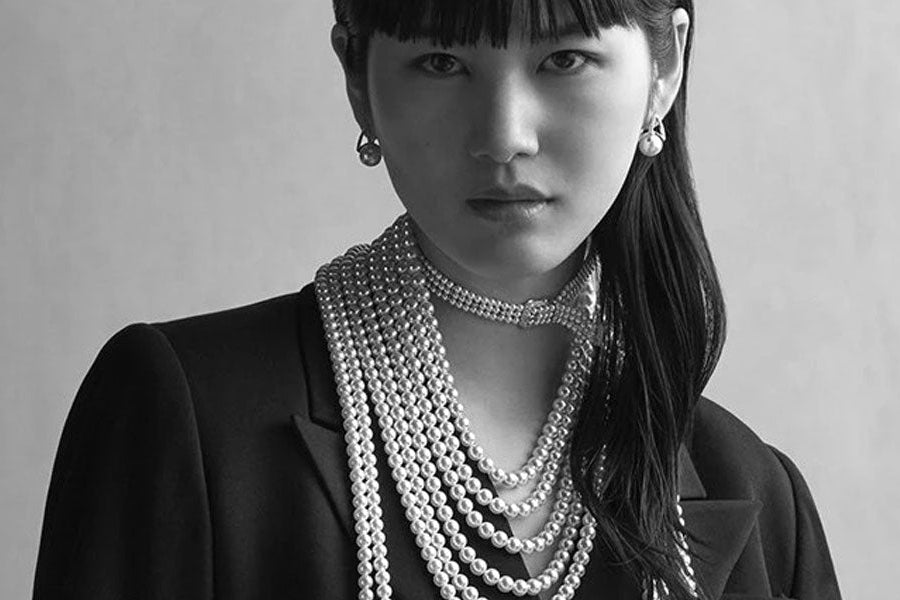 Woman wearing Mikimoto jewelry with the brand name displayed