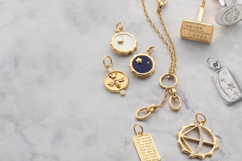 Collection of gold pendants on a marble surface