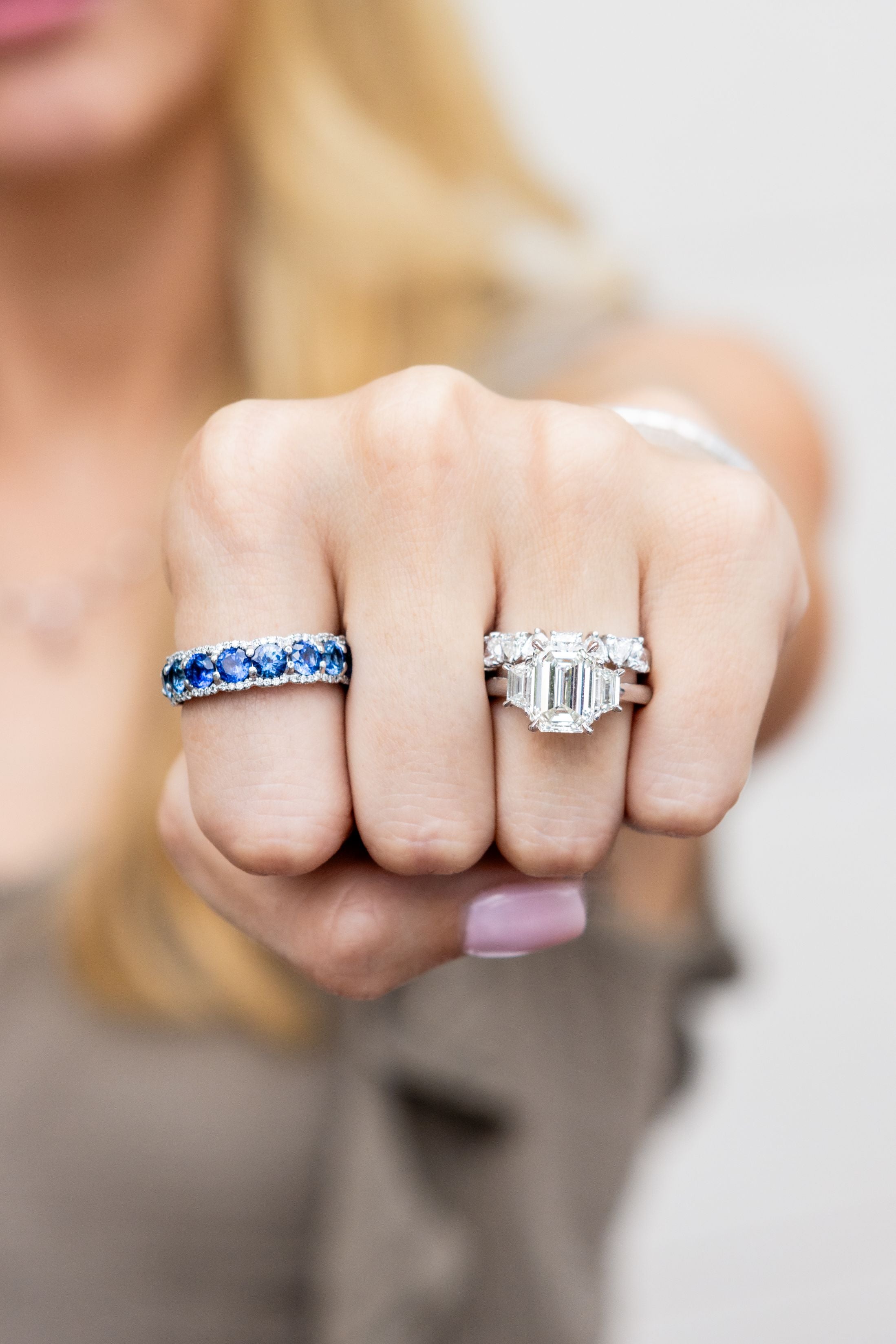 Close-up of a hand wearing three rings with a blurred background