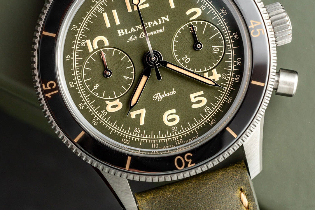 Blancpain watch with green face and leather strap on a dark background