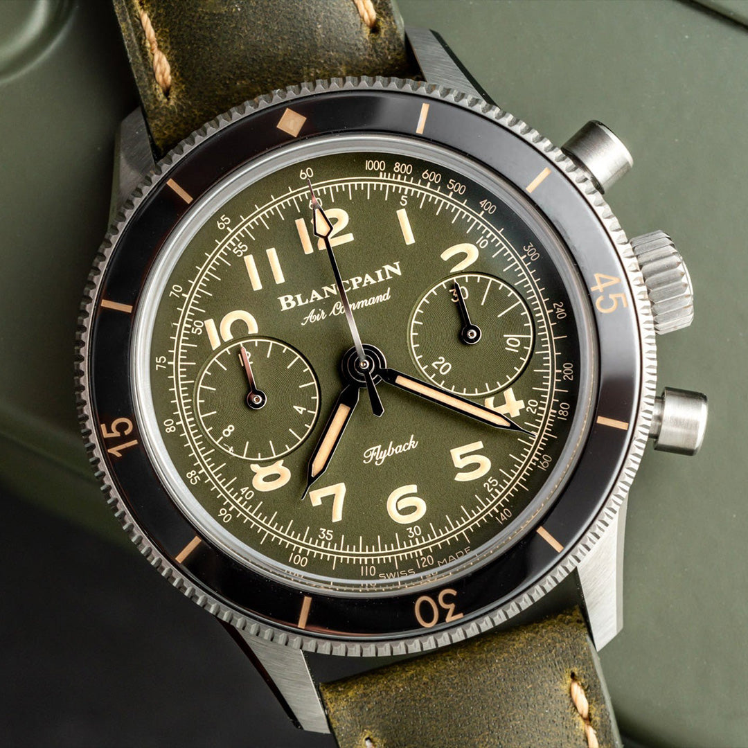 Blancpain watch with green face and leather strap on a dark background