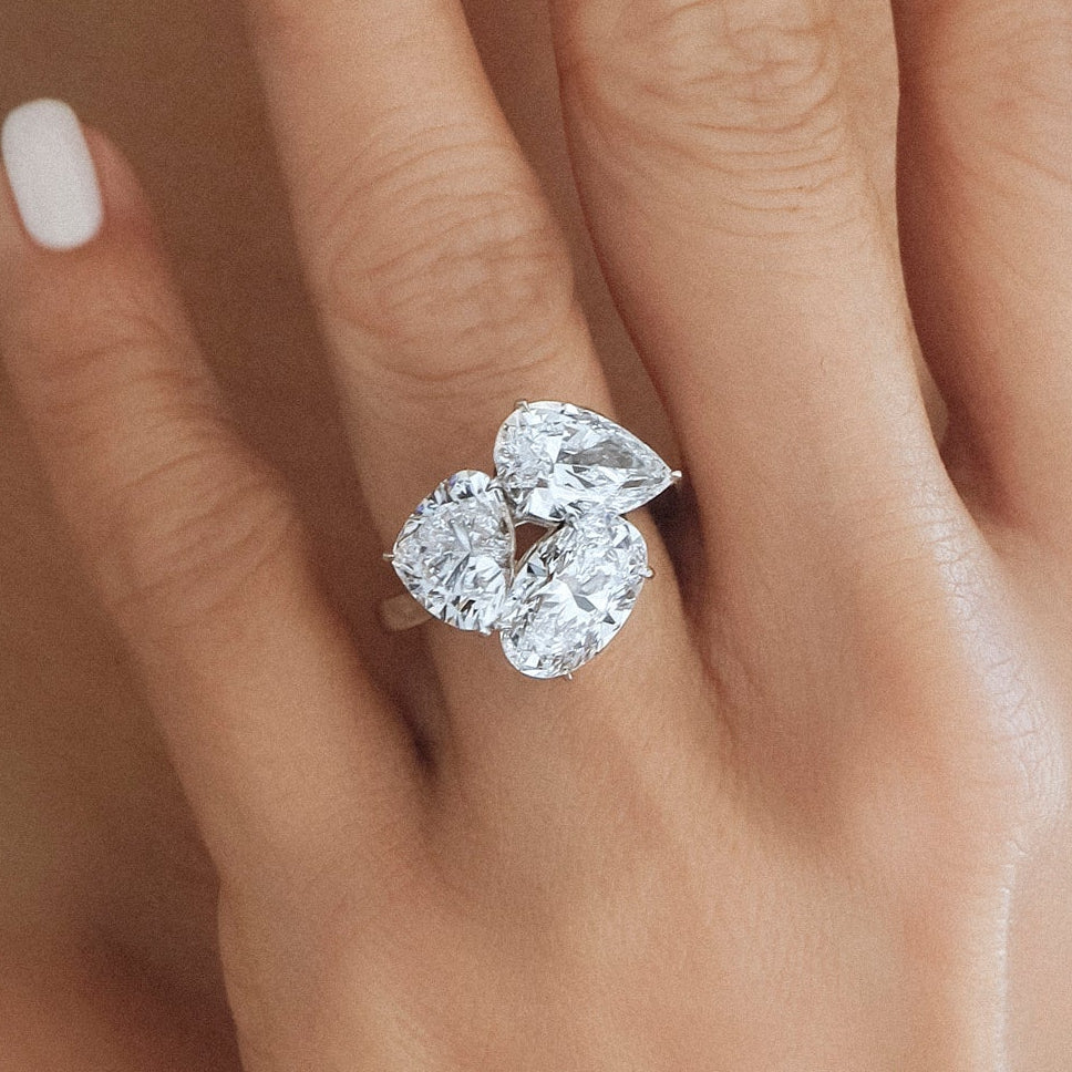 Close-up of a hand wearing a diamond ring with a blurred background