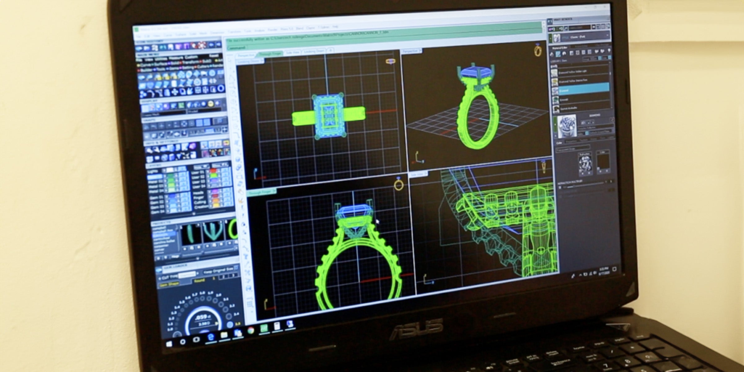 Computer screen displaying 3D design software with jewelry models on a desk.