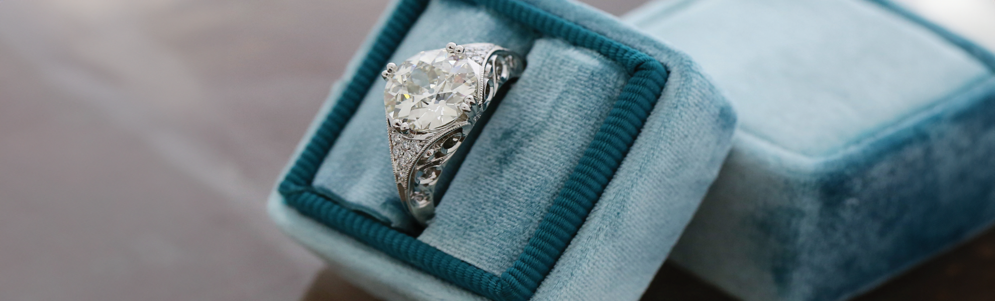 Diamond ring in a blue jewelry box on a blurred background