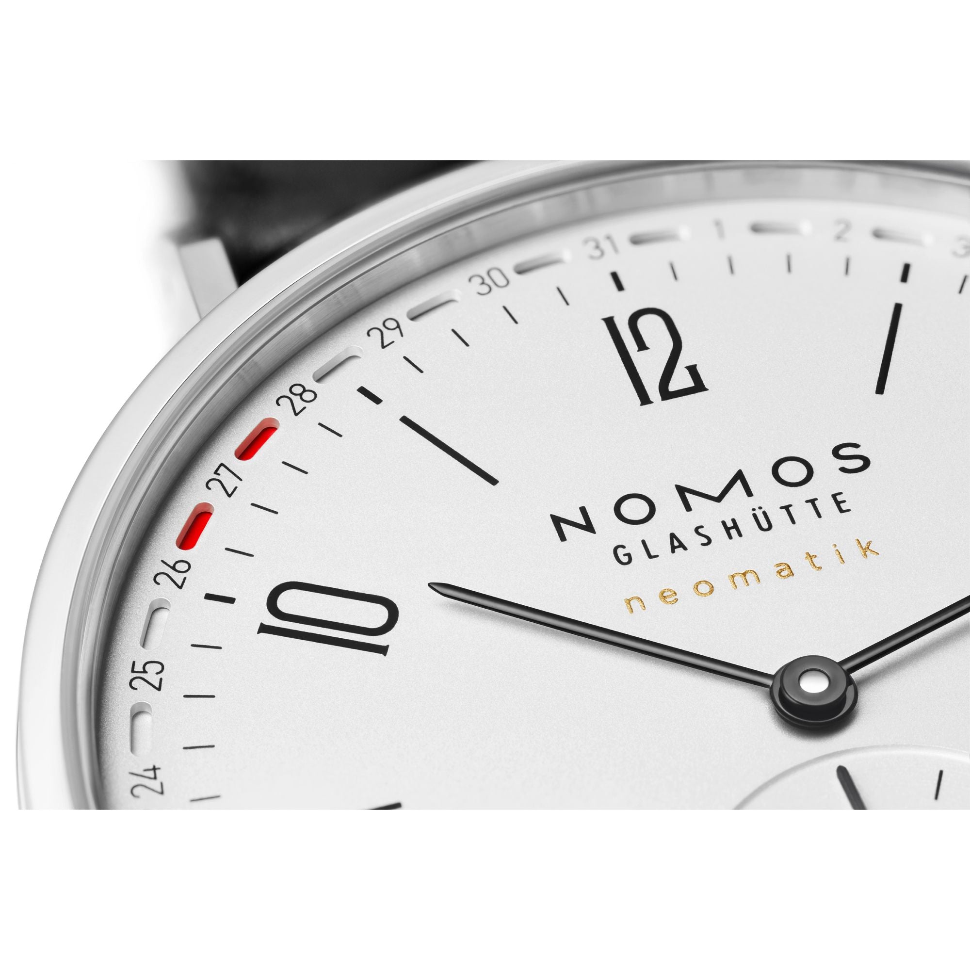 Close-up of a Nomos Glashütte Neomatik watch dial, showing a white face, silver-toned case, black numerals and hands, and small red accent markings near the 25-minute mark.