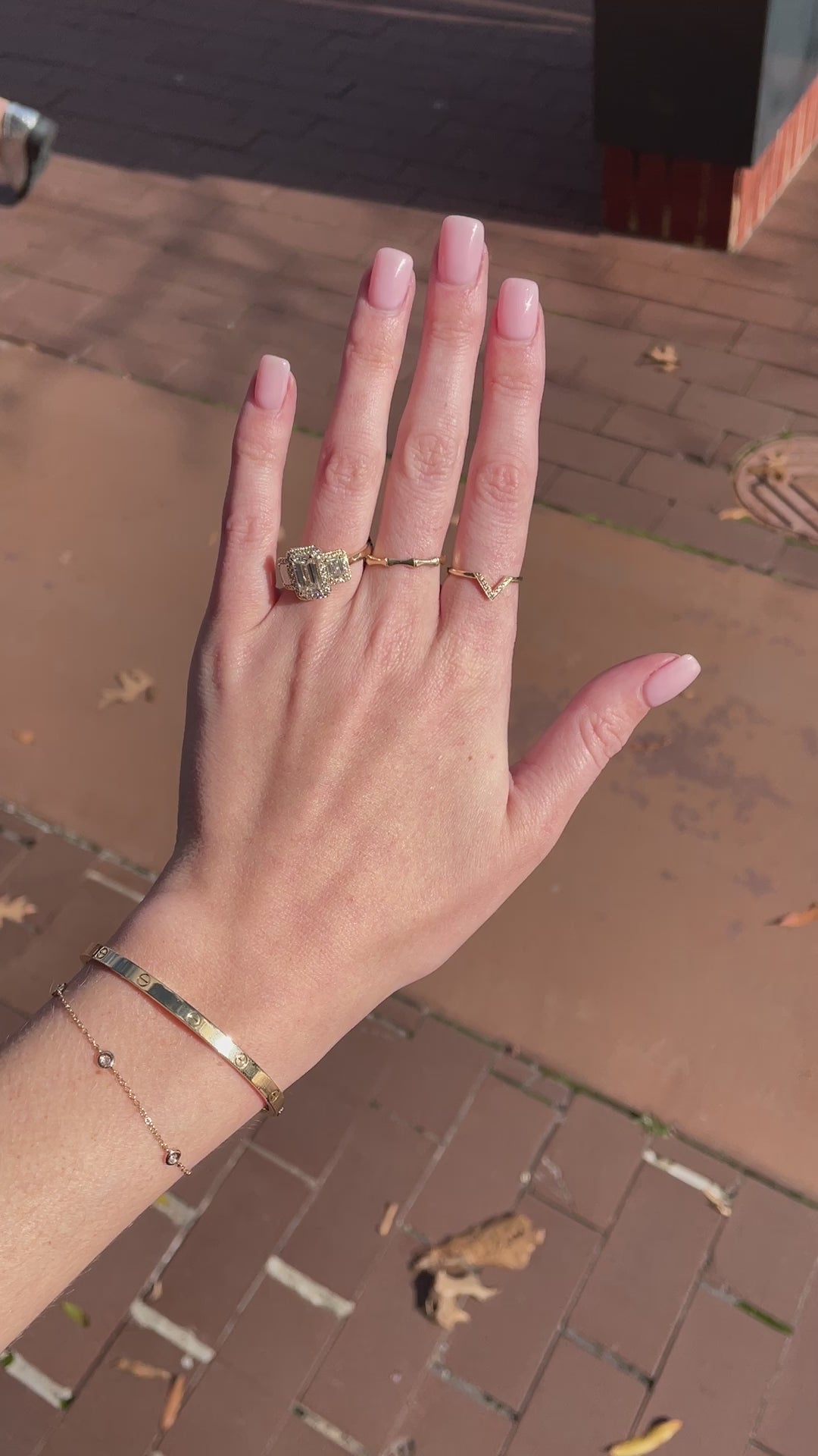 video close-up of rings and bracelets on hand and wrist over brown background