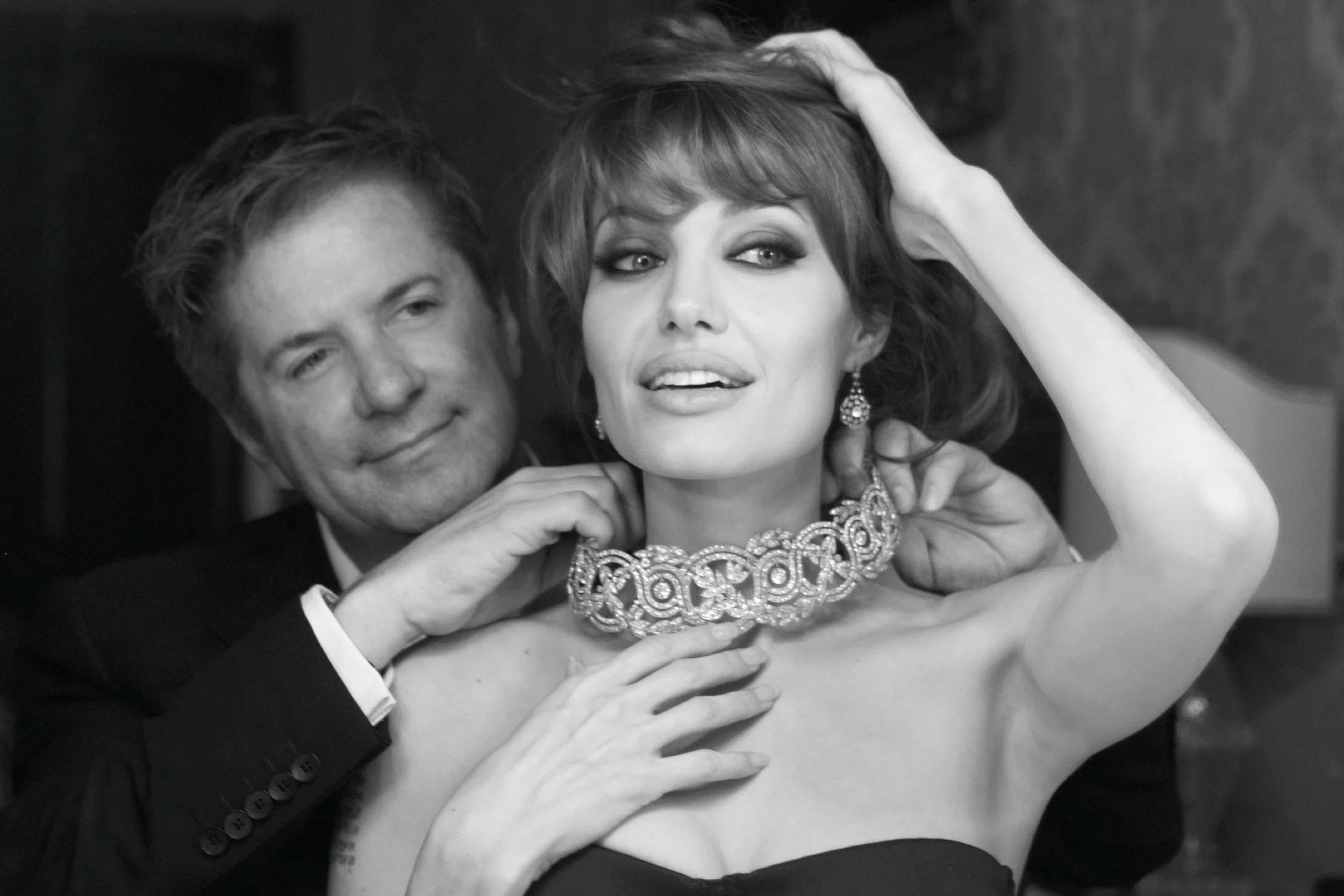 Black and white image of a man and woman with a woman wearing an ornate necklace.