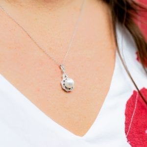 woman in white and red dress wearing a antique style pearl necklace