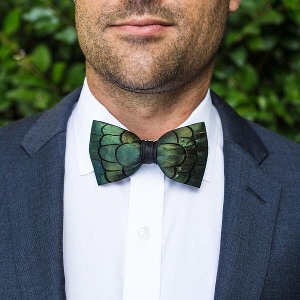 https://www.baileybox.com/wp-content/uploads/2021/01/Jeffery_brackish_bow_tie_with_rich_emerald_green_pheasent_feathers_and_hand_sticked_black_grosgrain_center_wrap_1.jpg
